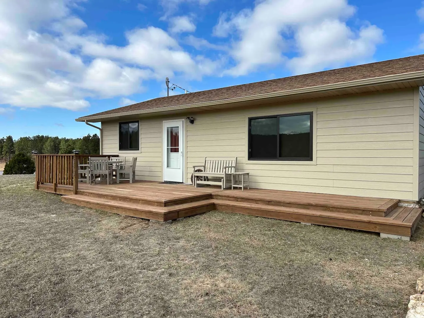 The cabin's south-facing deck with patio furniture under a bright blue South Dakota sky